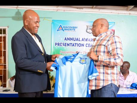 Kent Skyers (left), Discovery Bauxite’s public and community relations superintendent, is presented with a St Ann cricket team shirt by president of the St Ann Cricket Association, Keith Walford, as a token of appreciation for the bauxite company’s spo