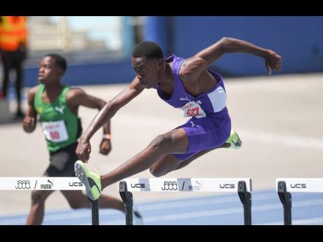 
Kingston College’s Timothy Purrier hurdles on his way to winning the Class Three boys’ 100-metre title at the Corporate Area Development meet inside the National Stadium yesterday.