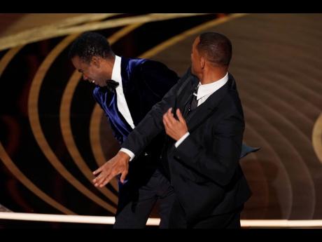 Credit: AP Will Smith, right, hits presenter Chris Rock on stage while presenting the award for best documentary feature at the Oscars on Sunday, March 27, 2022, at the Dolby Theatre in Los Angeles. Rock will be the first artiste to perform on Netflix’s first-ever