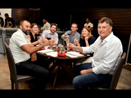 Round table cheers! From left: Nicholas Scott, managing director and vice-chairman of Eppley Limited; Butcher Block’s Kristen and Gregory Burrowes; David and Tania McConnell, and Andrew Desnoes of Select Brands toasted to Buzo.