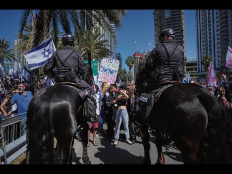Mounted police are deployed as Israelis block a main road to protest against plans by Prime Minister Benjamin Netanyahu’s new government to overhaul the judicial system, in Tel Aviv, Israel, yesterday.
