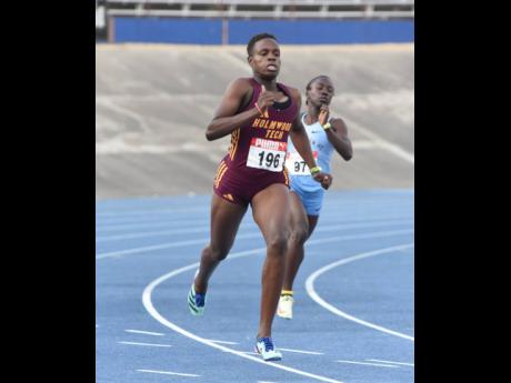 Credit: Ian Allen Rickiann Russell (left) of Holmwood Technical powers to victory in heat one of the under 20 girls’ 400 metres in 53.85 seconds during the Carifta Trials at the National Stadium yesterday.