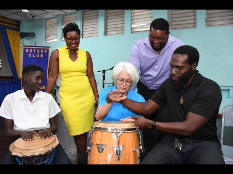 Professor Elizabeth Ward (second right), chair of the Violence Prevention Alliance (VPA), gets drumming lessons from Jesse Golding (right), Afro-Caribbean drumming instructor, at the launch of the VPA’s drumming programme at the Kingston Young Women’s 