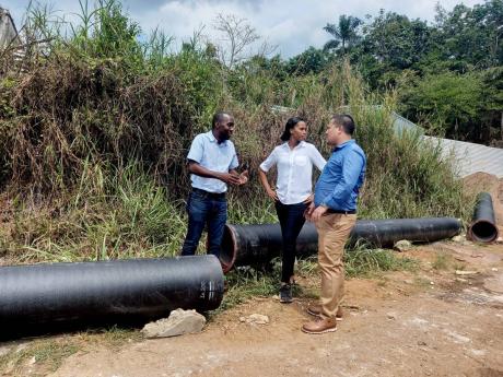 Minister without portfolio in the Ministry of Economic Growth and Job Creation Mathew Samuda (right), Member of Parliament Manchester Central Rhoda Crawford (centre), and a representative of the National Water Commission (NWC) in a  section of the Hopeton 