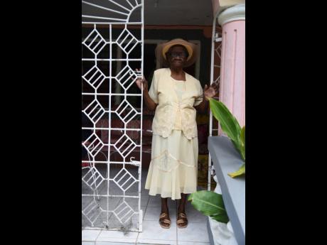 Keturah Campbell, 100 years old, shows she is still strong in body as she stands at the entrance to her home in Water Works, Westmoreland.