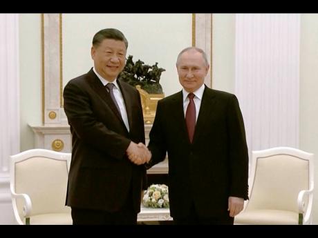 Credit: Uncredited China’s President Xi Jinping (left) and Russian President Vladimir Putin shake hands during their meeting in Moscow, Russia, yesterday.