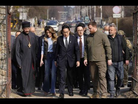 Japanese Prime Minister Fumio Kishida (centre) arrives at a church in Bucha, a town outside Kyiv that became a symbol of Russian atrocities against civilians, in Ukraine, yesterday.
