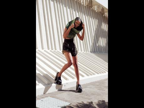 Right: 
The designer pairs this green cowl drop-shoulder crop top with zip closure with a black high-waist military shorts in pin-stripe wool and pistol black lined in khaki green linen. 