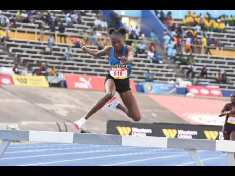 Hydel High School's Kaydeen Johnson attempts to clear the final hurdle on her way to the girls' Open steeplechase at the ISSA/GraceKennedy Boys and Girls' Athletics Championships inside the National Stadium earlier this evening. 