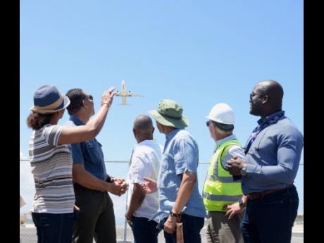 Credit: Ashley Anguin/Photographer From left: St James Central Member of Parliament (MP) Marlene Malahoo Forte waves as a flight takes off during a tour of Sangster International Airport runway expansion project in Montego Bay, St James, on Saturday. Also photographed are Prime Minister And