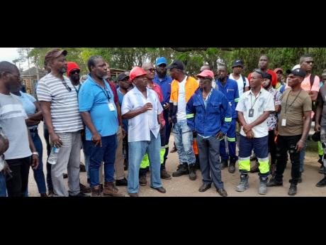 Credit: Photo by Ruddy Mathison UCASE President Vincent Morrison (centre) addressing workers at the Windalco bauxite plant in St Catherine on Monday as they protested outside the gate.