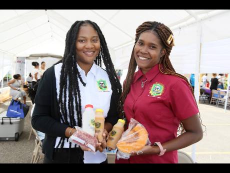 Kris-San Bailey (left), owner of Builders Power Punch, and Rashel Campbell display samples of their punch made from peanut and pumpkin at the expo.