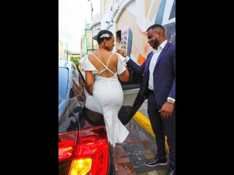 The handsome groom escorts his gorgeous bride into the car as they make their way to the wedding reception. 