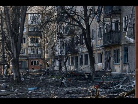 A local resident runs past the damaged houses in Bakhmut, the site of heavy battles with Russian troops in the Donetsk region, Ukraine, Sunday, April 9.
