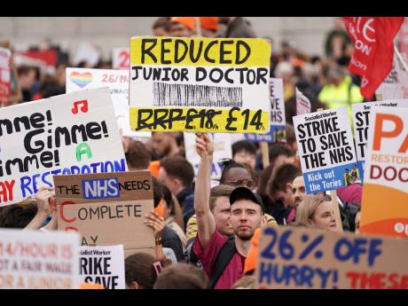 People take part in a rally in Trafalgar Square in support of striking NHS junior doctors, as the British Medical Association holds a 96-hour walkout in a dispute over pay, in London, Tuesday April 11, 2023. 