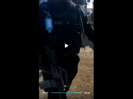 In this screen-grab from the video, the armed policeman is seen approaching 48-year-old businessman Boris Brown just before an ensuing tussle for his phone. 