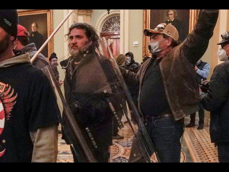Rioters, including Dominic Pezzola (centre), with police shield, are confronted by US Capitol Police officers outside the Senate Chamber inside the Capitol on January 6, 2021, in Washington. 