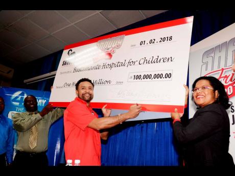 
In this February 2018 photo, international recording artiste Orville ‘Shaggy’ Burrell (centre) shows off a symbolic cheque for $100 million from the Shaggy Make a Difference Foundation, as Drs Brian James and Michelle Ann Richards Dawson of the Bustam
