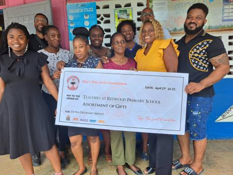 Teachers of Redwood Primary School in St Catherine pose with members of the Sky’s the Limit Foundation in celebrating the recent donations.