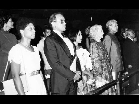Credit: File In this July 10, 1982 photo, a section of the audience stands in salute at the playing of the National Anthem. In front row from left are Beverley Manley; Harry Belafonte, guest speaker; Mrs. Belafonte; Edna Manley; and Michael Manley, son of National Hero