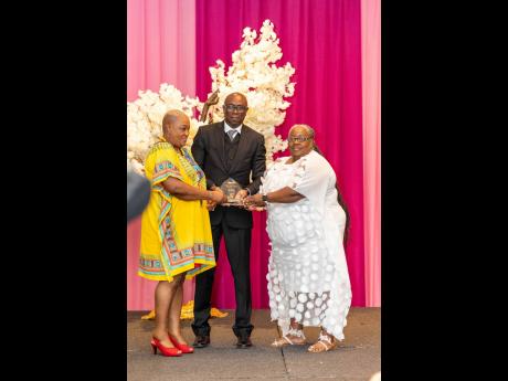 Credit: Jermaine Duncan Gracia Thompson (left), representing Dr Patricia Watson, and Joy Crawford are presented with the Pioneer Award for Volunteerism by Dalton Fowles, country manager for Jamaica, Trinidad, Barbados & Eastern Caribbean at Mastercard.