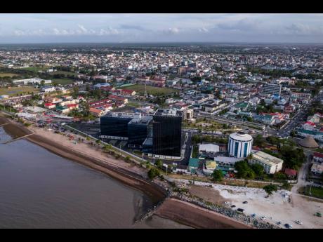 AP 
The Pegasus Suites and Corporate Centre (centre) which expands the original Pegasus hotel (right) and adds new commercial spaces, stands tall on the delta of the Demerara River and Atlantic Coast, in Georgetown, Guyana, Wednesday, April 12, 2023. 
