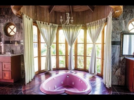 The main bathroom, with its heart-shaped spa tub looking out through curved walls of glass.