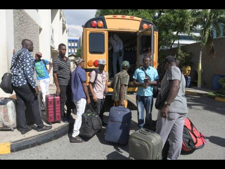 In this 2020 photo, farm workers wait to board a bus to the airport at Overseas Employment Services, a department of the Ministry of Labour and Social Security, East Street, to head to Canada.