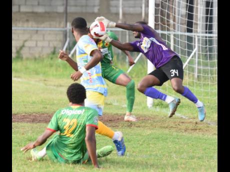 Credit: Ian Allen Waterhouse goalkeepe Kemar Foster (right), dives to his right to parry a shot from Humble Lion’s Karim Bryan (left) during their Jamaica Premier League football match at the Waterhouse Mini Stadium yesterday. The match ended 0-0.