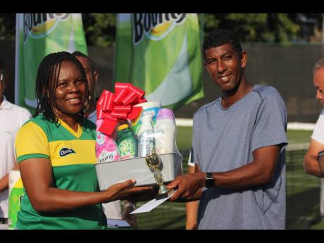 Credit: Lennox Aldred Men’s Open champion David Goldsmith collects his trophy and prizes from Clineice Brown, Merchandiser and team leader at Consumer Brands, following the final of the Bounty Invitational Tennis Classic at Couples Tower Isle yesterday.