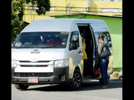 Passengers board a bus at the Montego Transportation Depot Montego Bay, St James on Thursday May 4.
