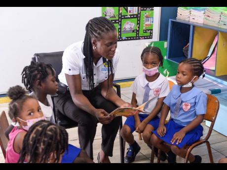 Corporate Services Director at the National Solid Waste Management Authority (NSWMA), Shenique Johnson, is fully engaged with these youngsters from the Webster Memorial Basic School on Half-Way Tree Road. Occasion was a Read Across Jamaica Day initiative b