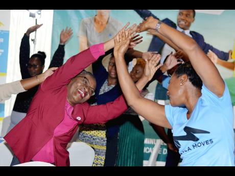 From left: Chief Nursing Officer Patricia Ingram Martin and Minister of State in the Ministry of of Health and Wellness Juliet Cuthbert-Flyn, do warm-up exercises at the Move for Health Day event  which featured the launch of the MOHW's  Physical Activity 