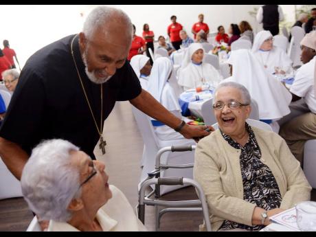 File photo shows Roman Catholic Archbishop Emeritus of Kingston, Rev. Donald Reece, chatting with Sister Celia Coolslartique (right) and Sister Maureen Clare Hall at the Catholic Schools’ Ministry Appreciation Luncheon for Unsung Heroines Religious Siste