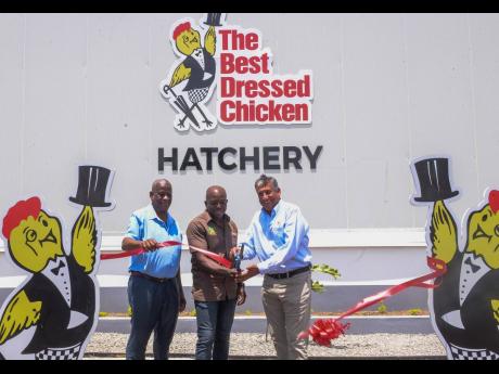 Credit: Contributed Minister of Agriculture and Fisheries Pearnel Charles Jr. (centre) and Group President and Chief Executive Officer of Jamaica Broilers Group, Christopher Levy (right), cut the ribbon to mark the official reopening of Best Dressed Chicken’s Cumberland Hat