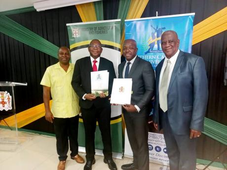 Credit: Contributed Minister of Agriculture and Fisheries Pearnel Charles (2nd right) and Northern Caribbean University President, Dr Lincoln Edwards (2nd left) exchange signed copies of an MOU to develop a National Organic Agriculture Policy. They are flanked by Permanent Se
