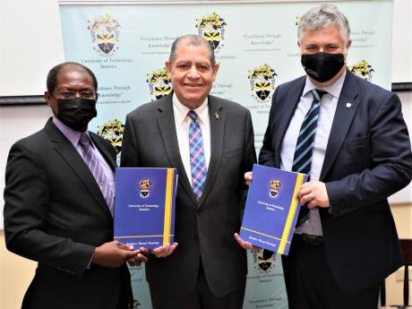 Audley Shaw (centre), minister of transport and mining, joins Professor Colin Gyles (left), acting president, University of Technology, Jamaica, and Professor Clive Roberts, head, School of Engineering, University of Birmingham, as they display copies of t