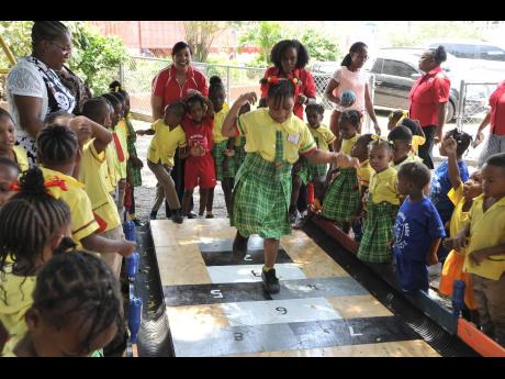 Credit: Contributed Karishma Forth completes her paces on the hopscotch drawn on the newly installed eco-friendly bowling alley at the Jebb Memorial Basic School.