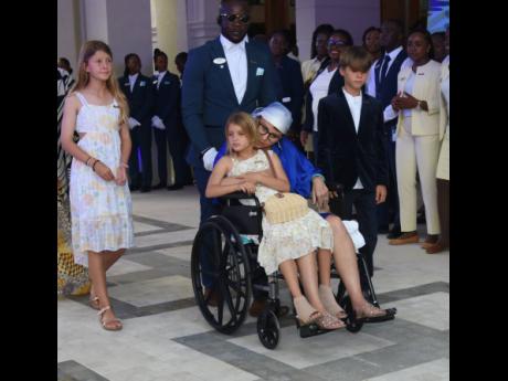 Credit: Ashley Anguin Jill Stewart, wife of the executive chairman of Sandals Resorts International, with her children (left) Sloane Stewart, Camden Stewart and Aston Stewart as she is being escorted by Vivian McIntosh at the Sandals Dunn’s River ribbon-cutting ceremony on Fr