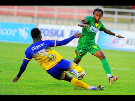 
Ajeanie Talbott (left) of Harbour View slides in to tackle Javon Smith of Humble Lion during their Jamaica Premier League (JPL) quarter-final match at Sabina Park this evening. Harbour View lost the match 3-2 but advanced to the semi-finals 4-3 on aggrega