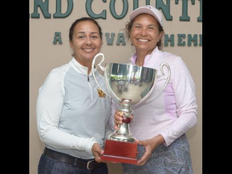 Credit: Contributed President of the Jamaica Golf Association Jodi Munn Barrow (left) presents the National Amateur Golf Championship trophy to Michelle McCreath.