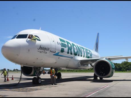 Credit: Ashley Anguin Captain Justin Brack Neff of Frontier Airlines waves the Jamaican flag as he arrives on the inaugural flight from Dallas-Fort Worth International Airport in Dallas, Texas, to the Sangster International Airport in Montego Bay on Monday, May 22.