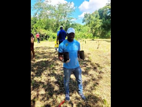 Clayon Freeman, Area Sales Manager at the Carreras Portland Depot gets ready to plant seedlings in the Fellowship Community in Portland.