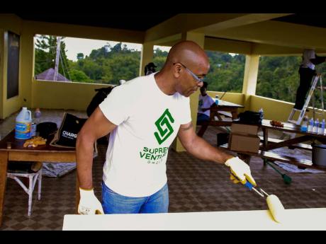 Mark Arthur, technical support manager of Supreme Ventures Limited, engages in Labour Day activities at the City of Refuge Children’s Home on Tuesday.