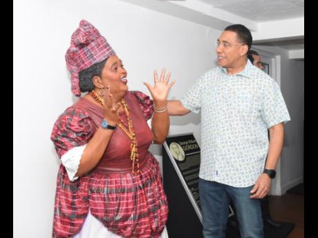 Credit: Ashley Anguin Prime Minister Andrew Holness pays tribute to the life-size statue dedicated to the late cultural icon Louise Bennett-Coverley.