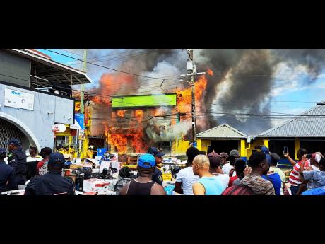Kamals Supermarket and Cambio and Portland Jewelers furniture and appliance store being consumed by fire in Port Antonio, Portland, yesterday.