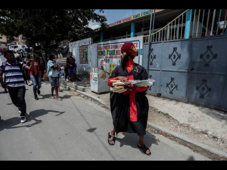 Nertil Marcelin, leader of a community group, goes door-to-door to distribute machetes to residents in Delmas district of Port-au-Prince, Haiti. 