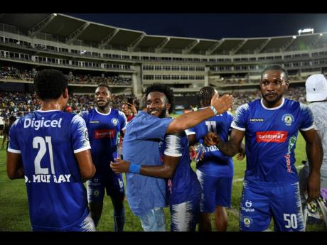 
Mount Pleasant owner Peter Gould (centre) congratulates players after their semi-final victory over Arnett Gardens at Sabina Park last Sunday. 