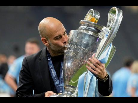 Credit: AP Manchester City’s head coach Pep Guardiola kisses the trophy after winning the Champions League final between Manchester City and Inter Milan at the Ataturk Olympic Stadium in Istanbul, Turkey on Saturday.