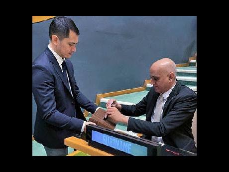 Suriname Permanent Representative to the UN, Ambassador Sunil Sitaldin (right), casting his vote.